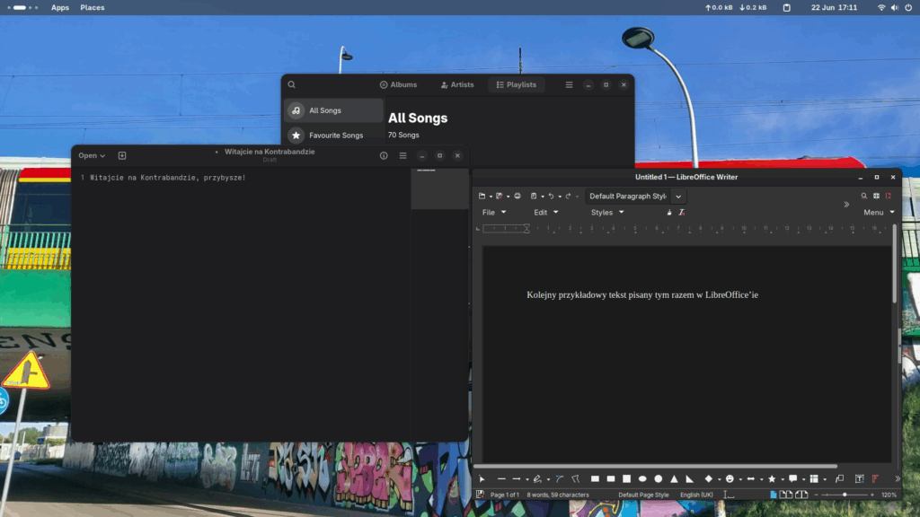 Trzy okna uruchomionych programów takich jak notatnik z tekstem "Witajcie na Kontrabandzie, przybysze!", LibreOffice Writerem z tekstem "Kolejny przykładowy tekst pisany tym razem w LibreOffice'ie", oraz -- za nimi -- odtwarzaczem muzyki