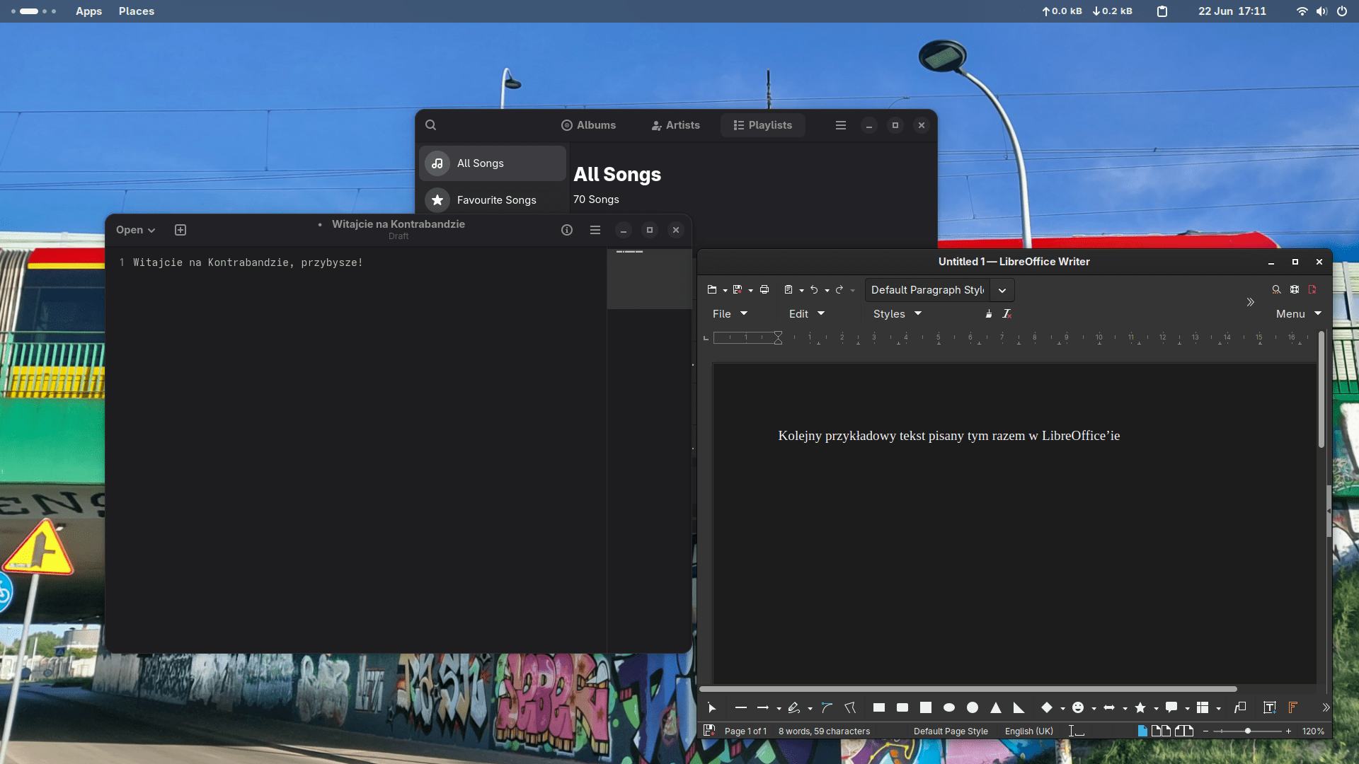 Trzy okna uruchomionych programów takich jak notatnik z tekstem "Witajcie na Kontrabandzie, przybysze!", LibreOffice Writerem z tekstem "Kolejny przykładowy tekst pisany tym razem w LibreOffice'ie", oraz -- za nimi -- odtwarzaczem muzyki