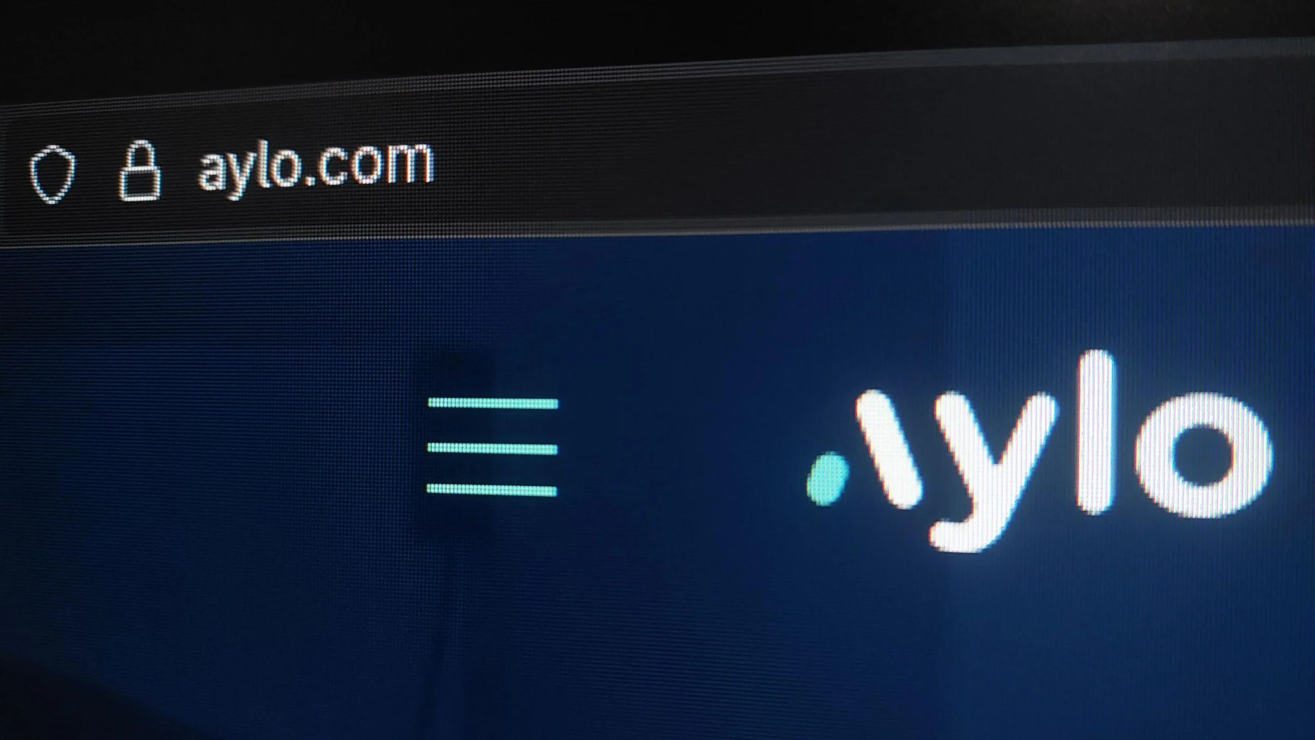 Logotyp firmy Aylo oraz pasek adresu w przeglądarce wskazujący na adres aylo.com