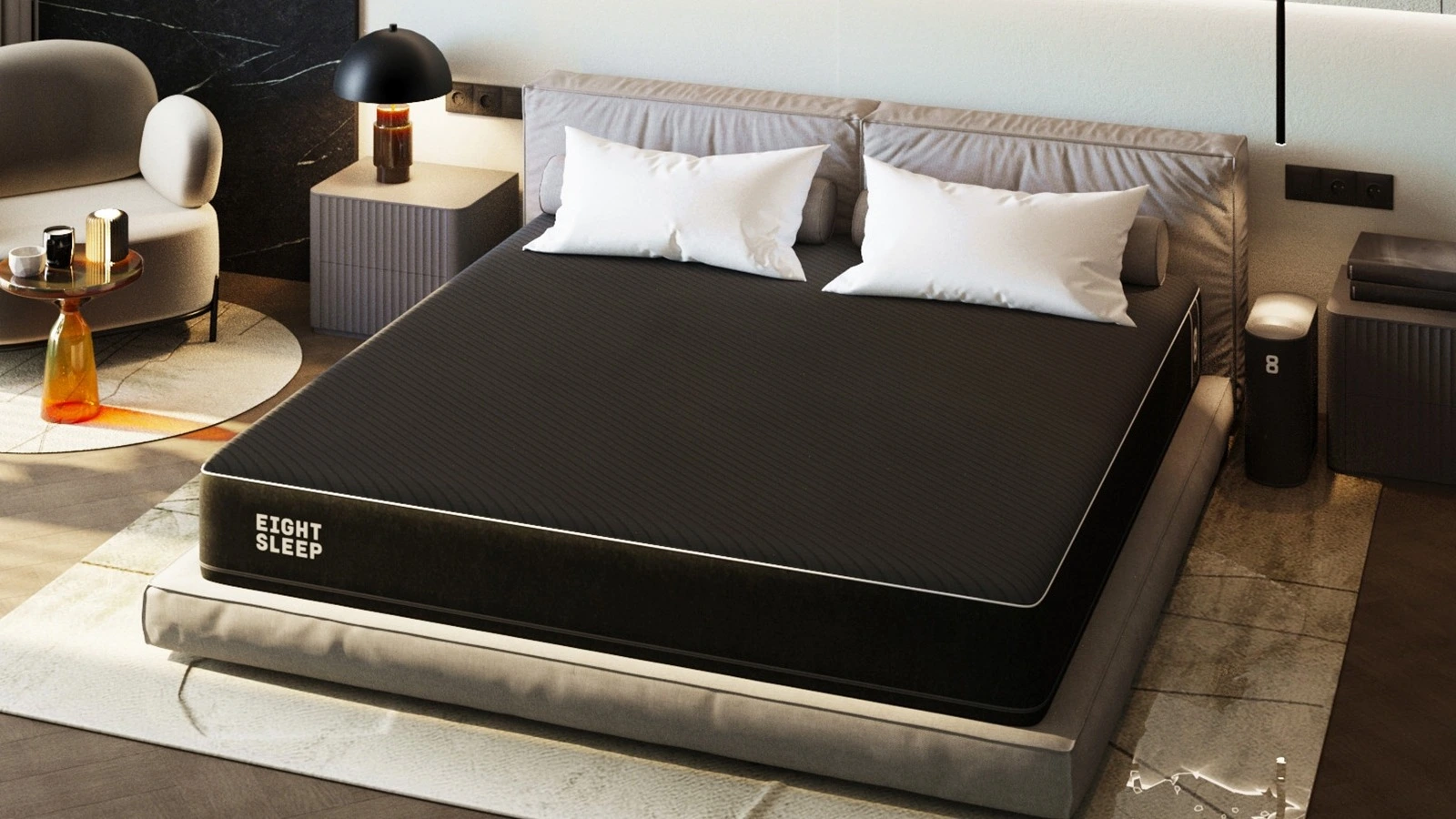 Czarny materac sygnowany logotypem „Eight Sleep” z położonymi na nim dwiema białymi poduszkami